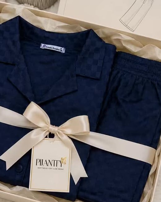 Close view of navy Pijamty fabric, cream ribbon and branded tag